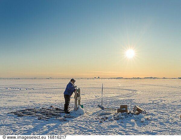 Fischer mit gefangenem Heilbutt auf dem Meereis der zugefrorenen Melville Bay  Teil der Baffin Bay  bei Kullorsuaq. Amerika  Nordamerika  Grönland  dänisches Gebiet.