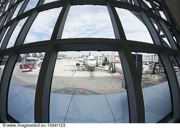 Fish-Eye-Objektiv-Ansicht von Flugzeugen geparkt auf Flughafen-Rollfeld aus Terminal-Fenster.