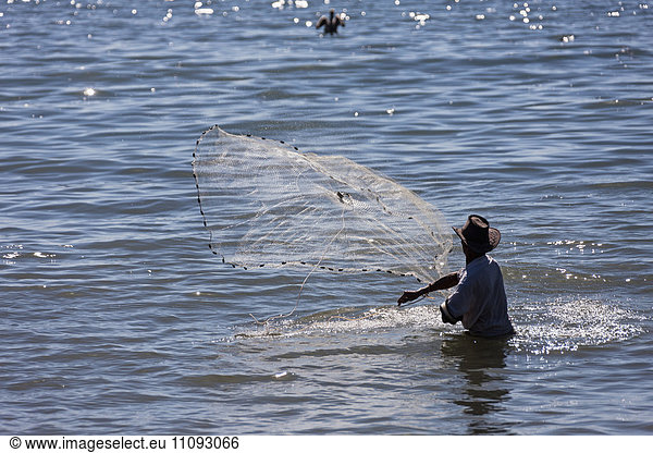 Fisherman spreading fishing net for catching fish in sea  Samara  Costa Rica