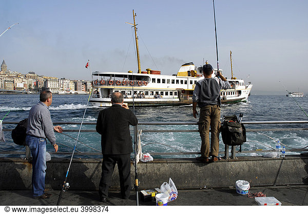 Fishers and port ferry on the Bosporus  Bogazici  between Eminoenue and Sirkeci  Istanbul  Turkey
