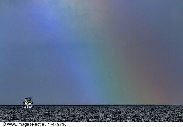 Fishing boat under rainbow in Indian Ocean