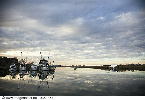 Fishing boats sit in the calm waters of a cove near Apalachicola Bay  FL.