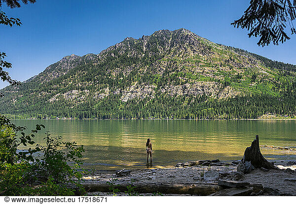 Fit female in a bikini standing in a mountain lake