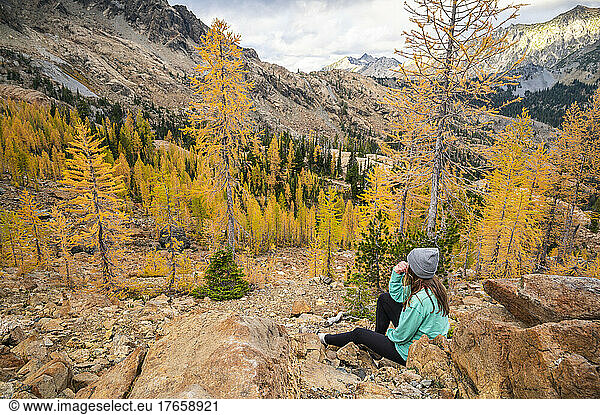 Fit female posing in a forest of alpine larches in the fall