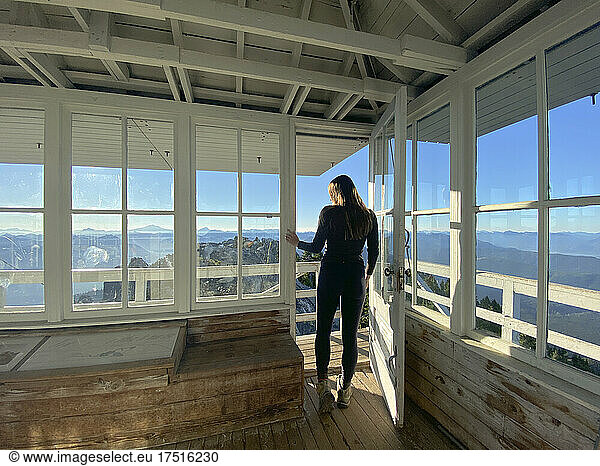 Fit female standing in a fire lookout in the north cascades