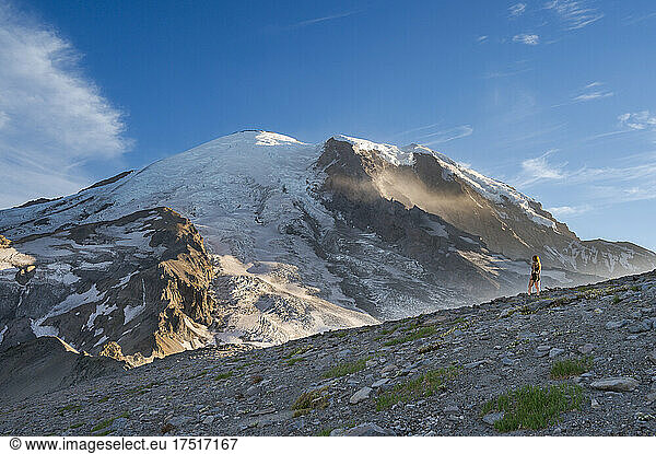 Fit female standing on a ridge next to Mount Rainier