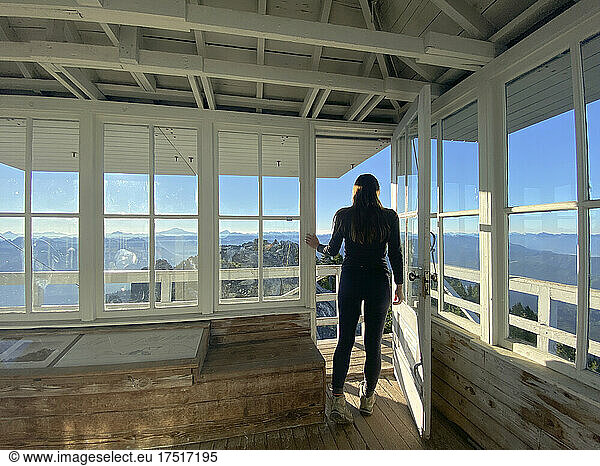 Fit female with leggings standing in a fire lookout door