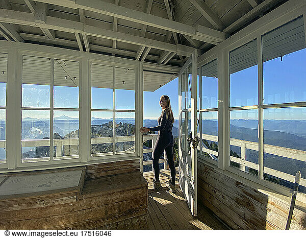 Fit girl in leggings standing in a fire lookout