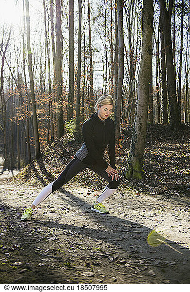 Fit woman stretching on fitness trail