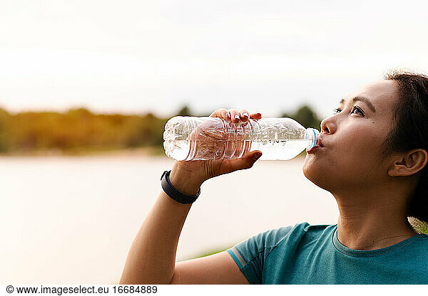 Fitness Asia Woman Drinking Water after Running