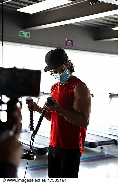 Fitness influencer recording his arm workout during COVID pandemic