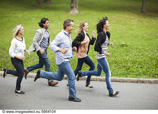 Five mature people running in park