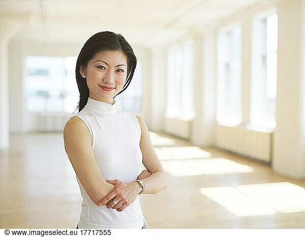 Fl6221  Huy Lam; Pleased Asian Businesswoman In Empty Office Space  New Business Concept