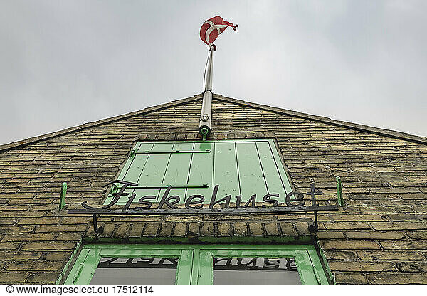 Flagpole with Danish flag on top of fishing store