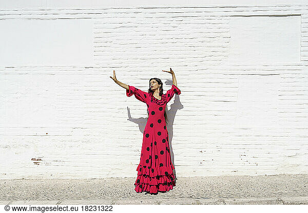 Flamenco dancer performing in front of white wall