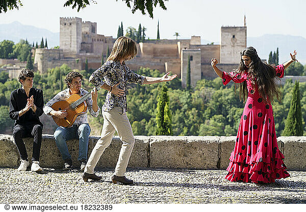 Flamenco dancers and guitarist performing in front of Alhambra  Granada  Spain