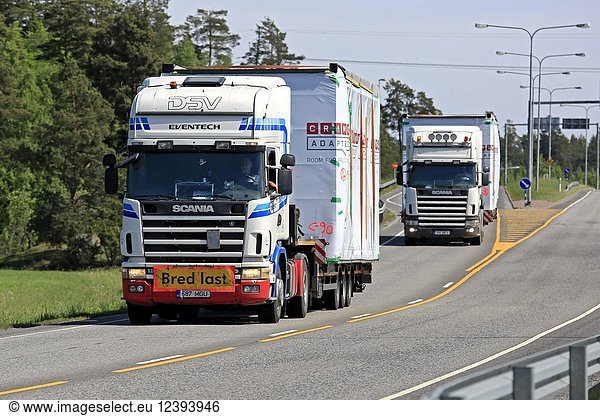 Fleet of two Scania semi trucks haul Cramo Adapteo Modular Space units as wide load on highway on a day of spring in Kaarina  Finland - May 27  2018.