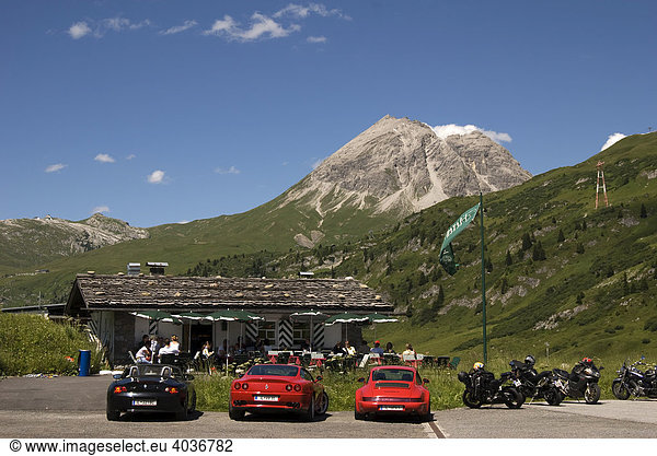 Flexenpass am Arlberg  Sportwagen vor Almhütte mit alpinem Hintergrund