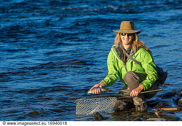 Fliegenfischerin landet Forelle mit Netz auf Fluss  Britisch-Kolumbien  Kanada.