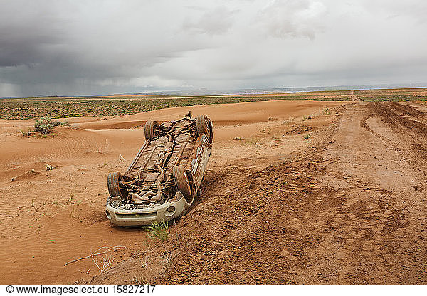 flipped upside car off the road on a desert dirt backroad in utah