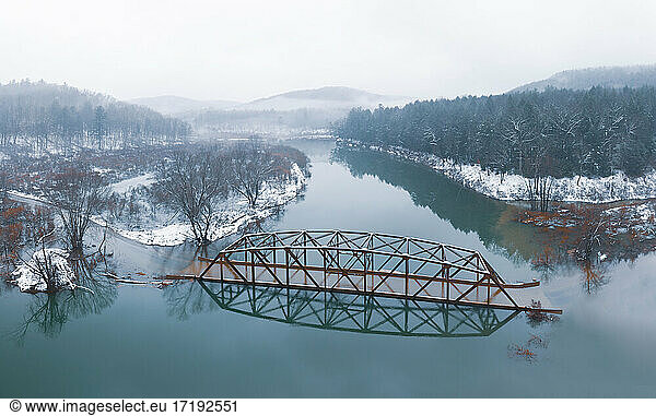 Flooded Bridge in Snowy Mountains from Above