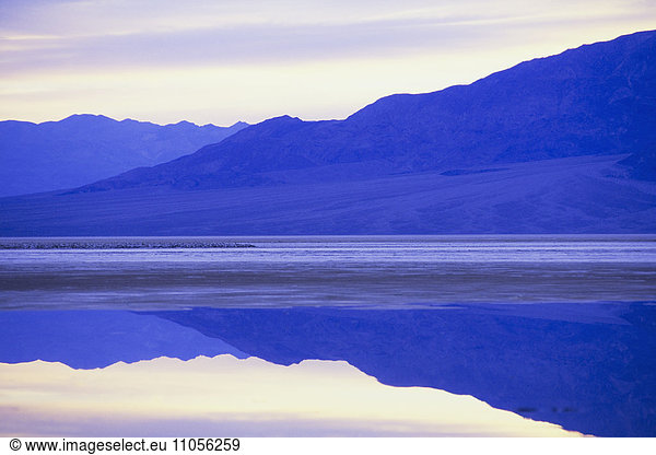 Flooded salt flats at dawn and Panamint Mountains in distance.