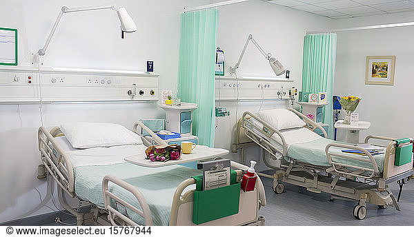 Flowers on trays over hospital beds in vacant hospital ward