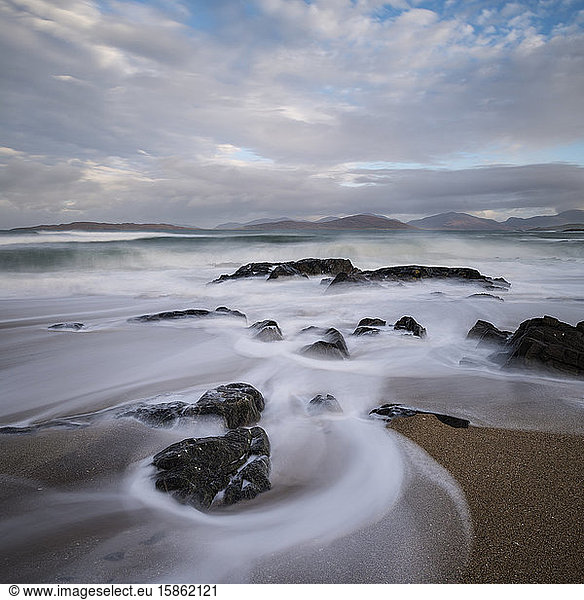 Flowing waves across small rocky beach  near Scarista  Isle of Harris  Scotland