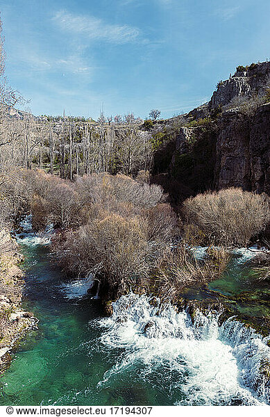 Fluss mit Wasser mit Wasserfall mit grünen und gelben Tönen und Bäumen an den Seiten im Fluss Escabas in der Stadt Priego in der Provinz Cuenca in Spanien