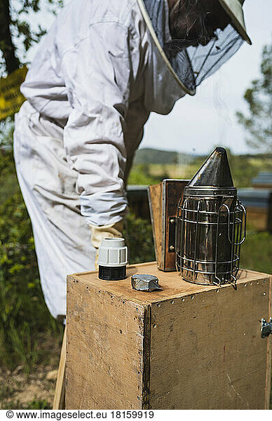 Focus selective of smoker with a beekeepers at work.
