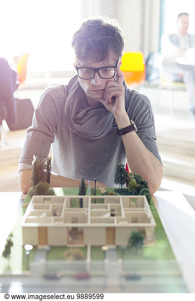 Focused architect viewing model in office
