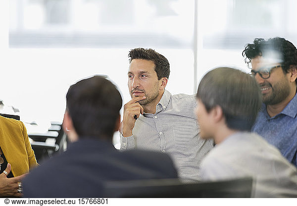 Focused businessman listening in conference room meeting