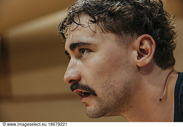 Focused male athlete with mustache at sports court