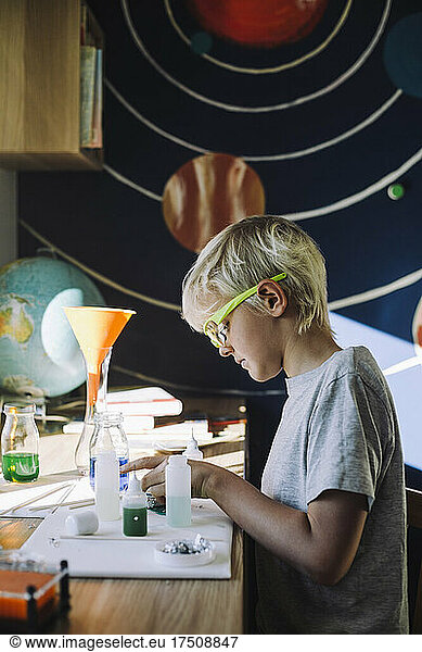 Focused male scientist doing school science project at home