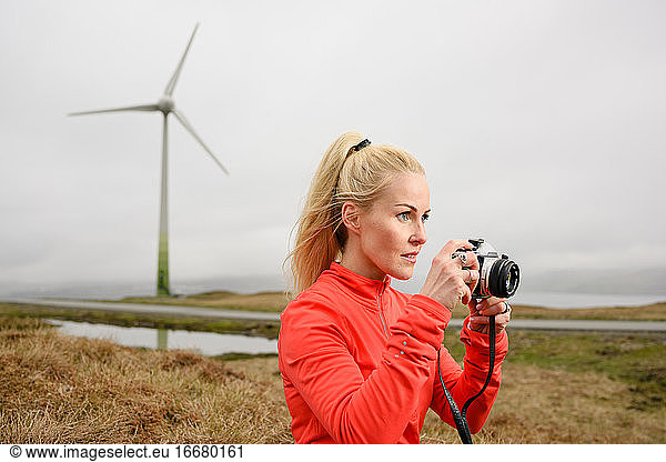 Focused photographer near wind turbine