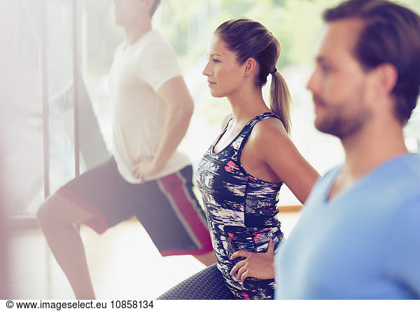 Focused woman lunging in exercise class