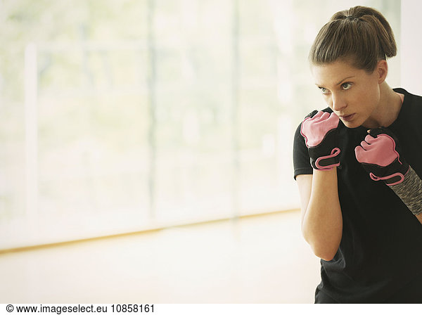 Focused woman shadow boxing in gym studio