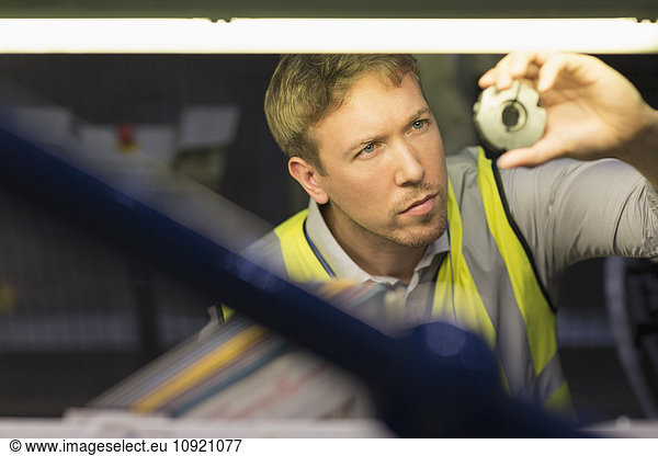 Focused worker inspecting part in steel factory