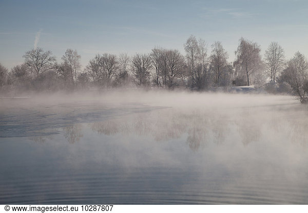Fog over lake in winter  Eichenau  Fürstenfeldbruck  Bavaria  Germany