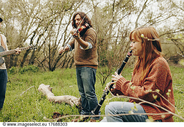 Folk music group playing musical instruments in field