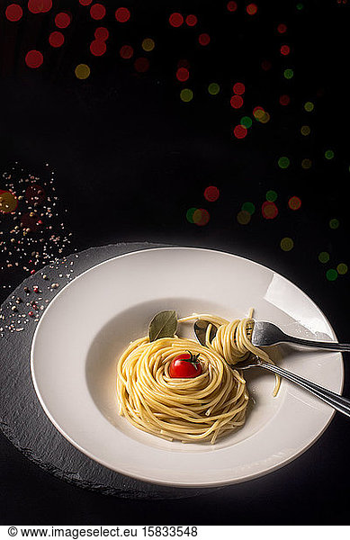 Food-Konzept mit Spaghetti und Kirschtomaten auf beleuchtetem b