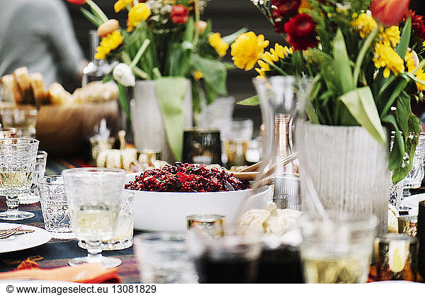 Food with drinks by flower vases served on table