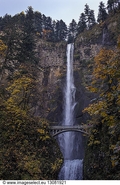 Footbridge against waterfall