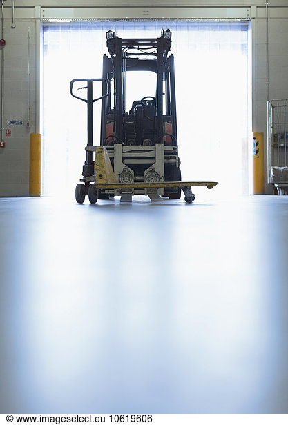 Forklift parked in warehouse loading dock doorway