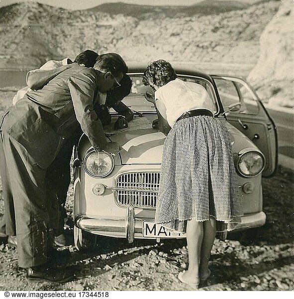 Former People's Republic of Yugoslavia in 1959: young German tourists on a coastal road i  studying a map spread out on the bonnet of their car  Croatia  Europe