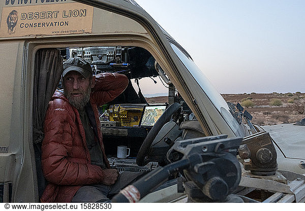 Forscher steht in seinem Fahrzeug in der namibischen Wüste