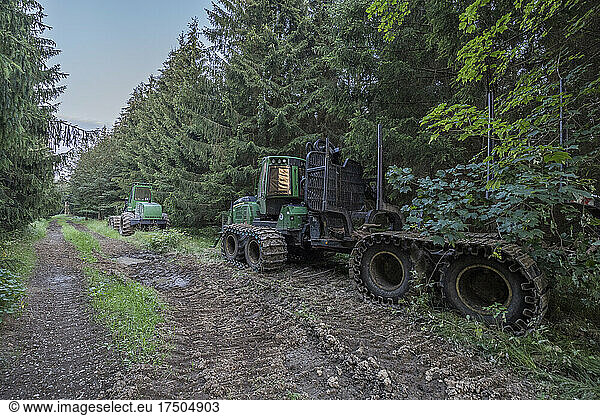 Forwarder parked along muddy forest road