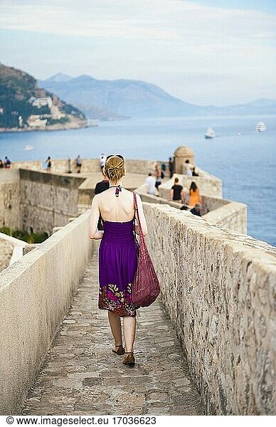 Foto eines Touristen  der auf der Stadtmauer von Dubrovnik spazieren geht  Altstadt von Dubrovnik  Kroatien. Dies ist ein Foto von einem Touristen  der auf den Stadtmauern von Dubrovnik spazieren geht. Für Touristen sind die Stadtmauern von Dubrovnik eines der beliebtesten Ausflugsziele in der Altstadt von Dubrovnik.
