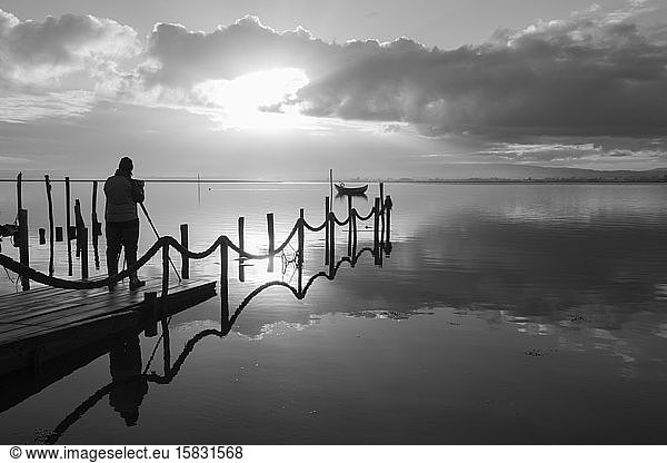 Fotograf beim Fotografieren des Holzbootes bei Sonnenaufgang