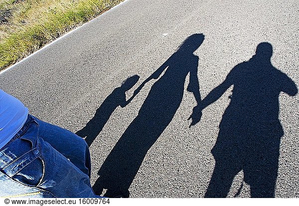 Fotografie Schatten einer Familie hält die Hände auf der Straße.